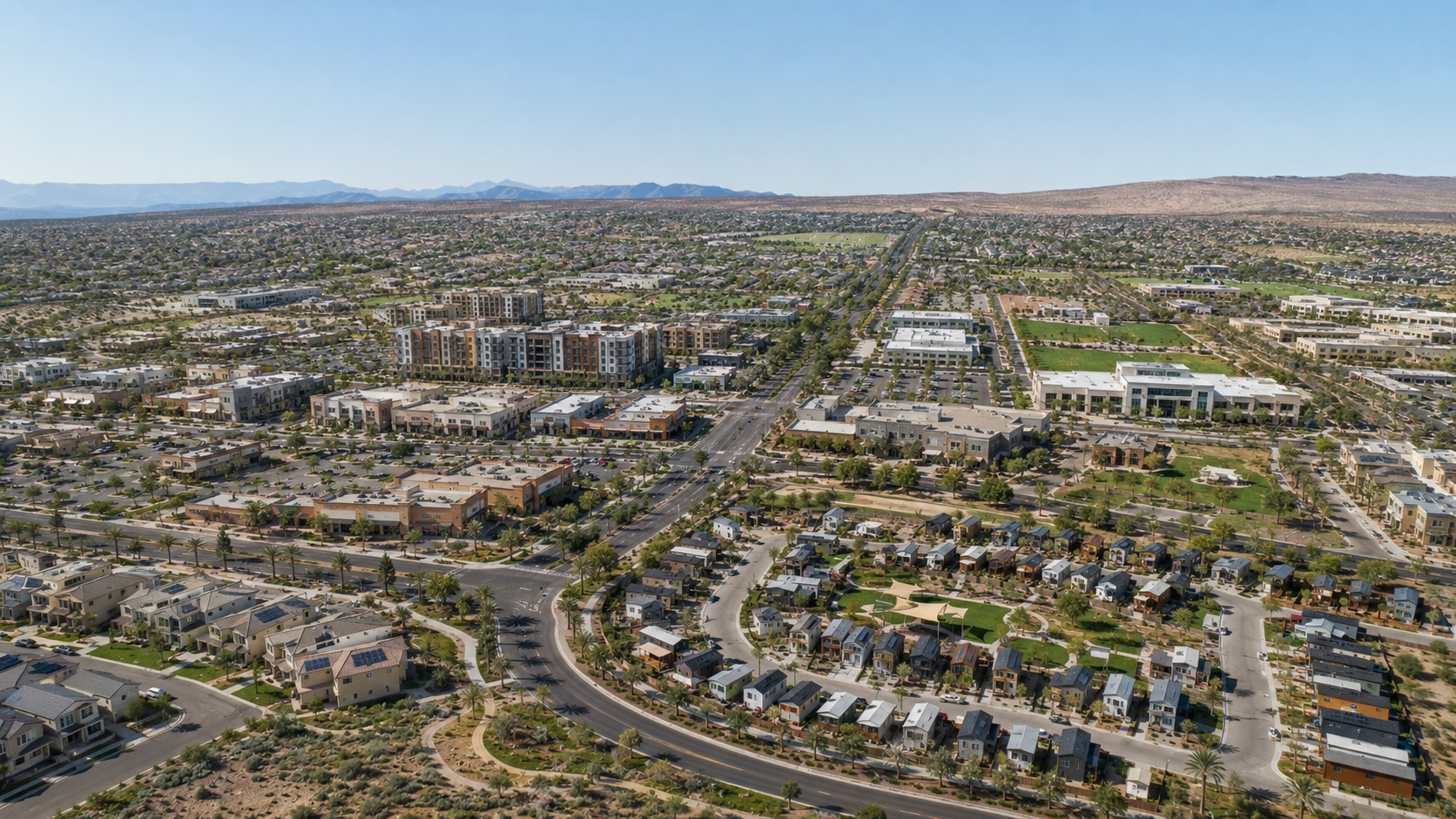 Aerial view of the Founder Sass Society planned community in California's high desert. Houses, roads, green space and distant mountains.